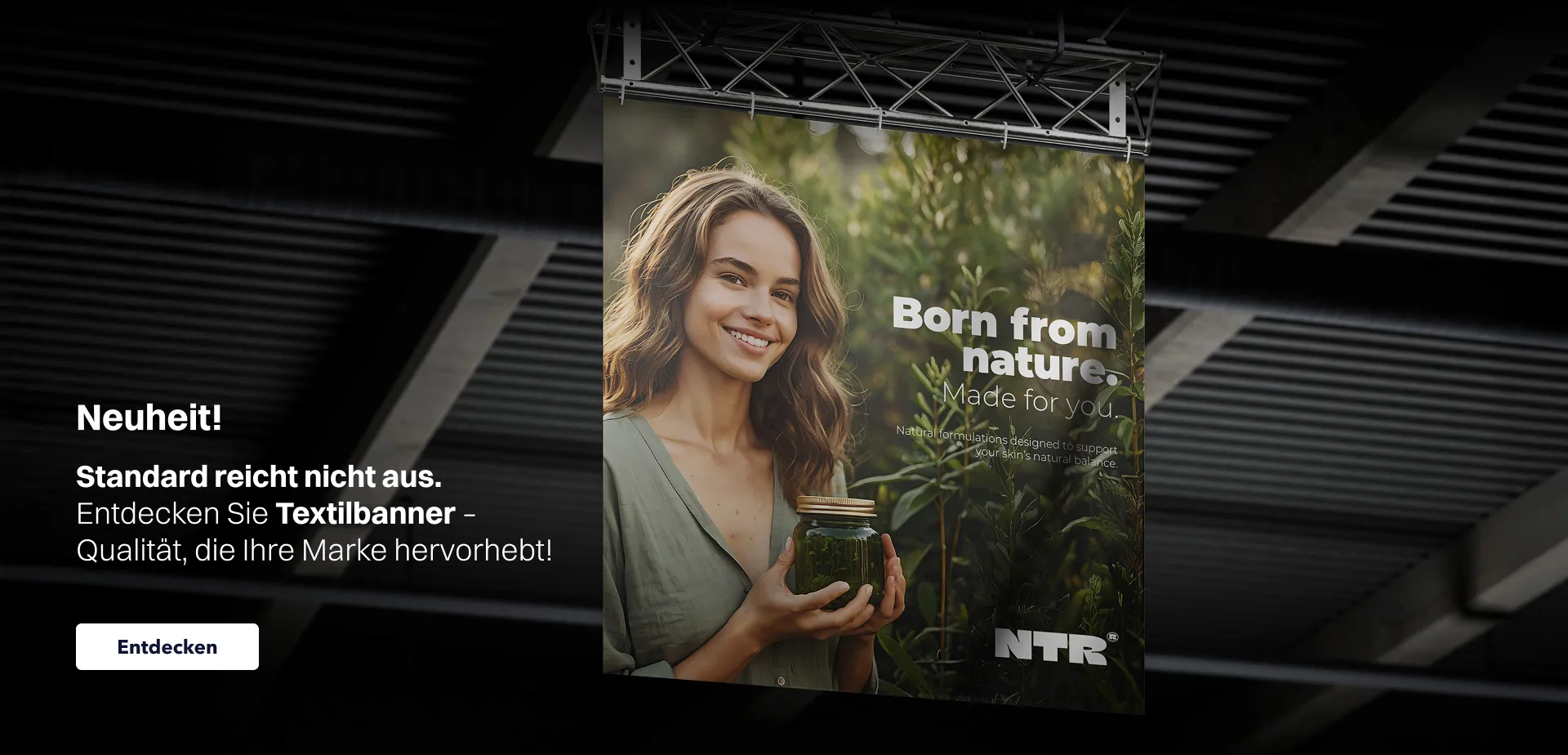 Website-Banner zur Bewerbung von Textilbannern mit dem Text „Neuheit! Entdecken Sie Textilbanner – Qualität, die Ihre Marke hervorhebt”